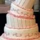 Ivory and pink wedding cake with bride and groom