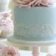 Pastel blue wedding cake with pink roses and lace