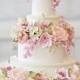 Triple tier ivory wedding cake with colorful flowers