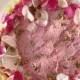 Light pink raspberry wedding cake decorated with rose petals
