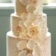 بتلات بيضاء أقراص سكرية والرباط تفاصيل تتالي أسفل بلطافة هذا كعكة الزفاف أربعة مستويات.