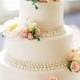 كعكة الزفاف مع الوردي والزهور البيضاء