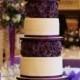 Layers Of Deep Purple Fondant Roses Contrast Against Tiers Of Sleek White Cake.