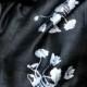 Black woven silk scarf. Hand silkscreened "Poppy" design, silver and black. Fair trade raw silk.