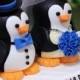 A penguin couple wedding cake topper. / blue roses
