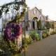 Wrought-iron Gates Covered In Purple Flowers And Vines Leads To An Over-the-top Tent Decorated To Look Like A Freestandi...