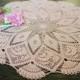 Pale pink or salmon colored tender round tablecloth or crochet doily