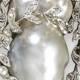 An Early 20th Century Pearl And Diamond Brooch. The Baroque Pearl Set Within A S