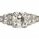 Circa 1920s Art Deco Platinum 1.17ct Antique Cushion Cut & .12cttw Old European Brilliant Cut Diamond Engagement Ring - VEG#1047