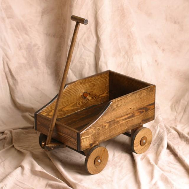 flower girl pulling baby in wagon