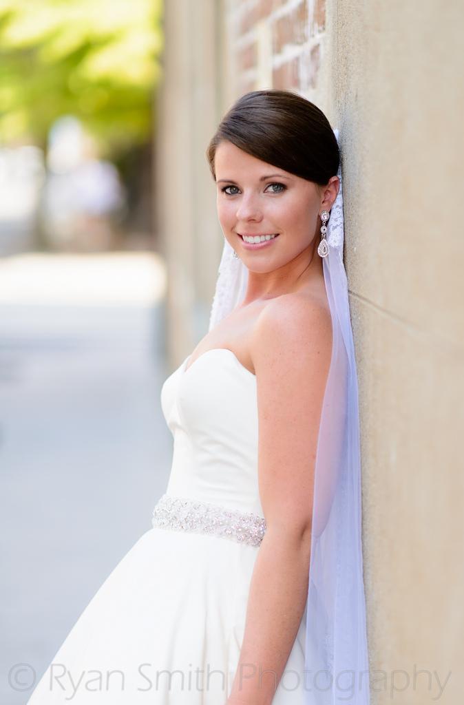 زفاف - Bride leaning against brick wall