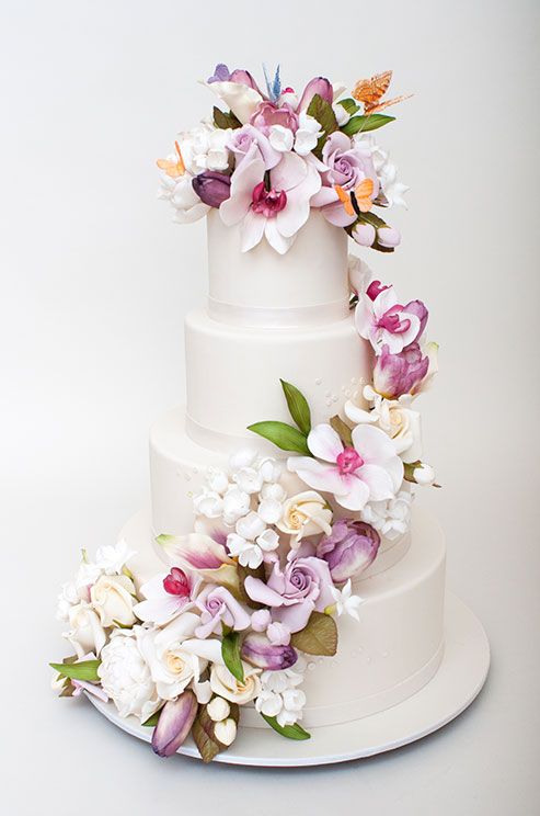 Hochzeit - Stunning Sugar Flowers And Colorful Butterflies Are Fabulous Against An All-white Wedding Cake.