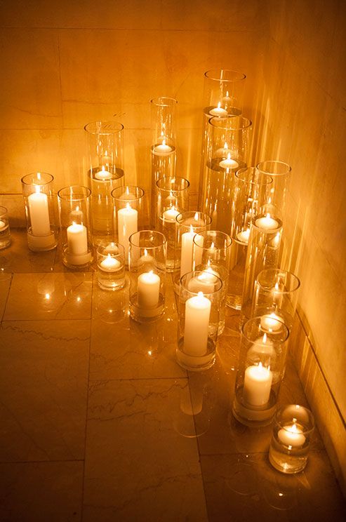 Hochzeit - Pillars And Floating Candles Project And Romantic Amber Glow In A Corner Of This Venue.