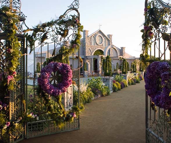 Hochzeit - Wrought-iron Gates Covered In Purple Flowers And Vines Leads To An Over-the-top Tent Decorated To Look Like A Freestandi...