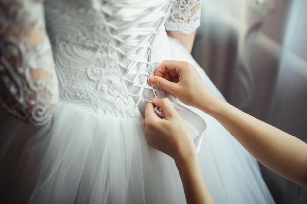 زفاف - Download Bridesmaid Makes Bow-knot On The Back Of Brides Wedding Dress for free
