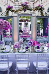 wedding photo - Three Large Mirrors Back The Head Table, Showing Off The Purple Cake And Dramatic Floral Arrangements.