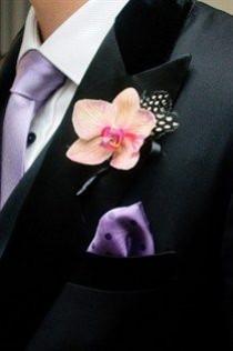 wedding photo - A Bright Pink Orchid Boutonniere Is Dressed Up With A Black And White Spotted Feather.