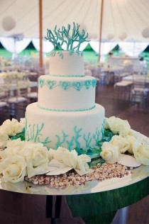 wedding photo - The Three-tier Wedding Cake Is Decorated With Turquoise Swags And Topped With Sugar Coral.