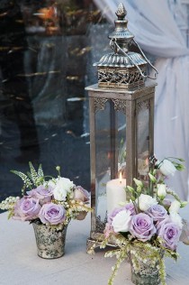 wedding photo - An Ornate Silver Lantern Was Arranged With Mercury Vases Of Lavender And White Roses.